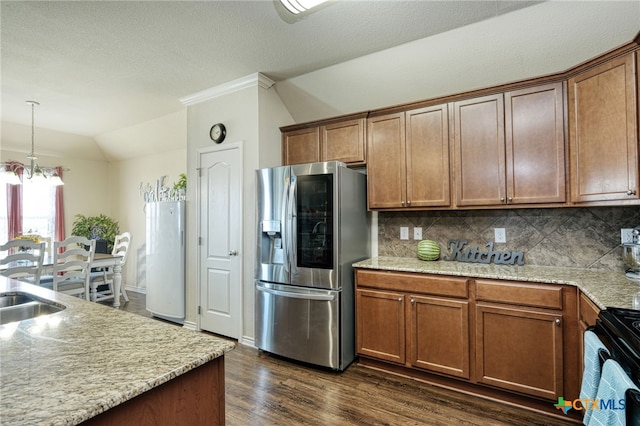 kitchen with backsplash, black range, vaulted ceiling, stainless steel fridge, and a chandelier