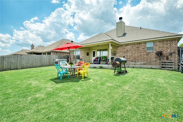 back of property featuring a patio area and a yard