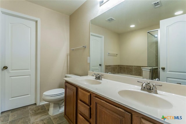 bathroom featuring vanity, an enclosed shower, and toilet