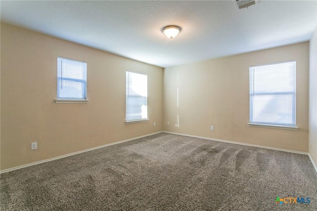 carpeted spare room featuring plenty of natural light