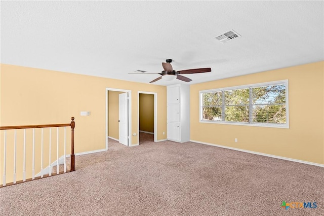 spare room with light colored carpet and ceiling fan