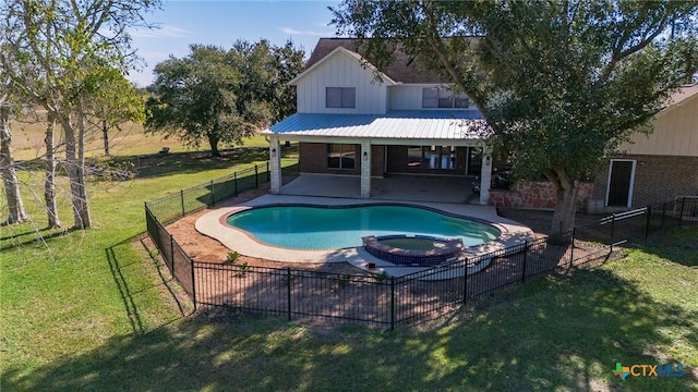 view of pool with an in ground hot tub, a lawn, and a patio