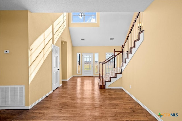 foyer featuring wood-type flooring and a high ceiling