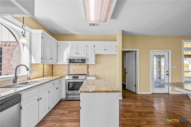 kitchen featuring ventilation hood, white cabinetry, sink, stainless steel appliances, and light stone countertops