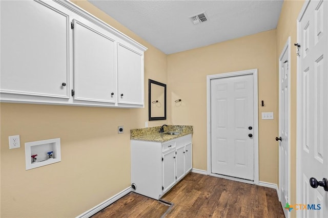 clothes washing area featuring sink, cabinets, dark hardwood / wood-style floors, hookup for a washing machine, and hookup for an electric dryer