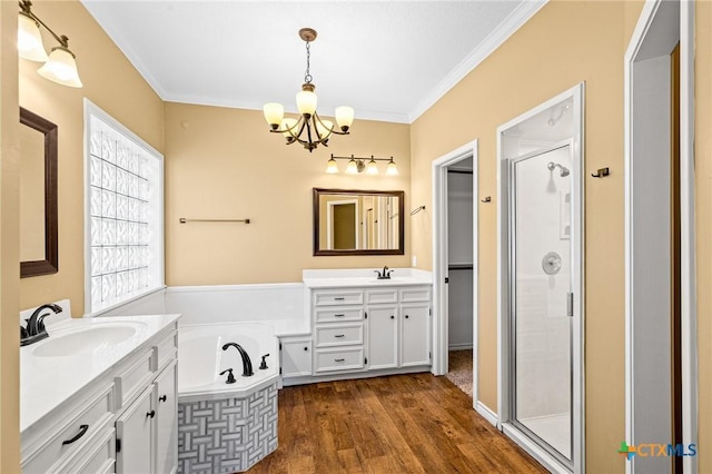 bathroom featuring crown molding, wood-type flooring, a chandelier, vanity, and independent shower and bath