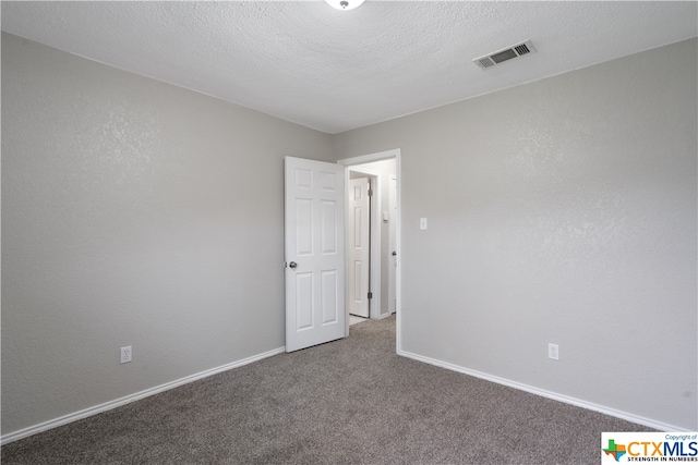 carpeted spare room featuring a textured ceiling