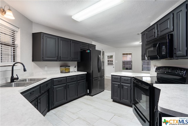 kitchen featuring black appliances, sink, and a textured ceiling