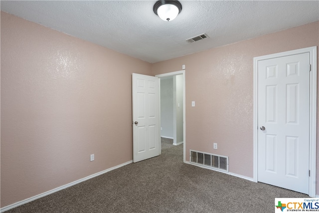 unfurnished room with carpet and a textured ceiling