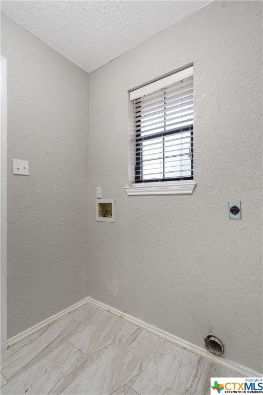 clothes washing area with a textured ceiling, electric dryer hookup, and hookup for a washing machine