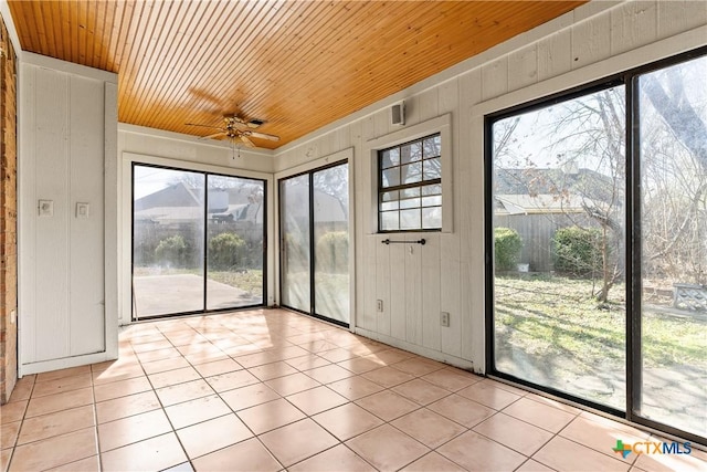 unfurnished sunroom with a ceiling fan and wood ceiling