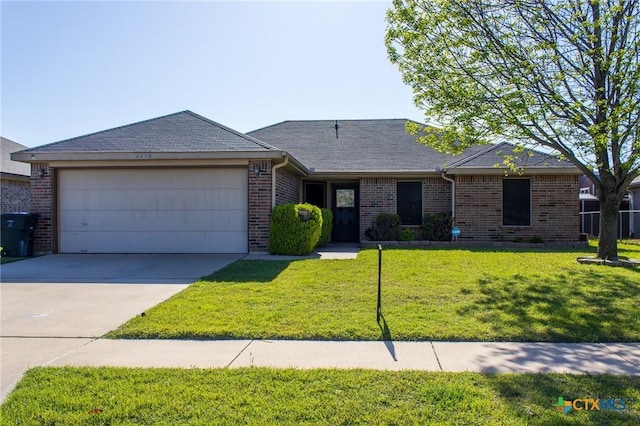 ranch-style house featuring an attached garage, concrete driveway, brick siding, a front lawn, and roof with shingles