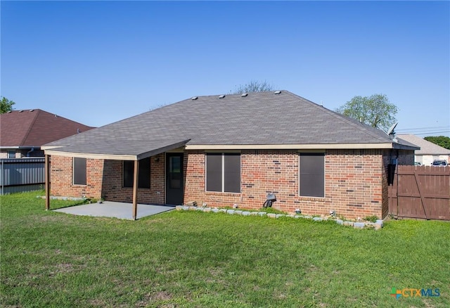 rear view of house with a patio area, brick siding, fence, and a lawn