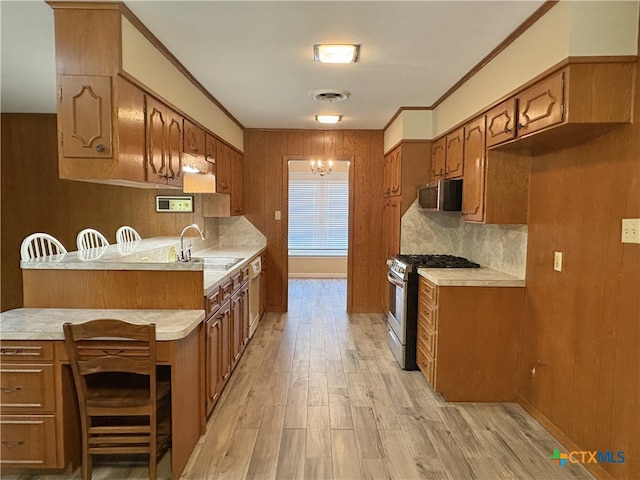 2602 Miori Ln, Victoria, TX 77901 - kitchen with stainless steel appliances, a sink, light countertops, tasteful backsplash, and light wood-style floors
