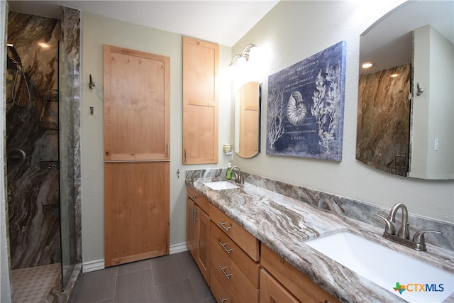 bathroom with a shower, vanity, lofted ceiling, and tile patterned flooring