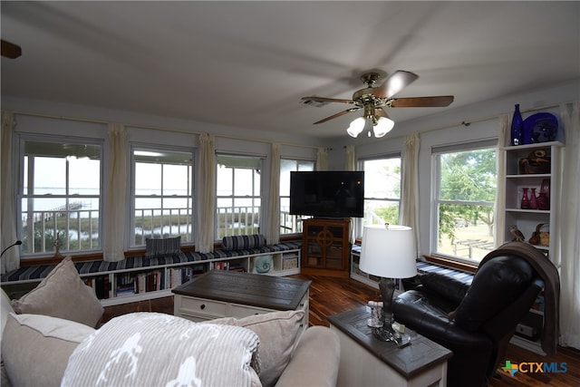 living room featuring ceiling fan, wood-type flooring, and a water view