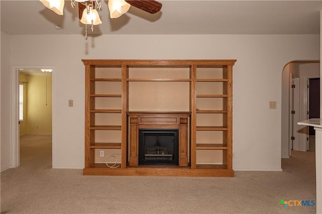 3259 Wren Brook Dr, New Braunfels, TX 78130 - unfurnished living room with carpet floors, a fireplace, a ceiling fan, and arched walkways