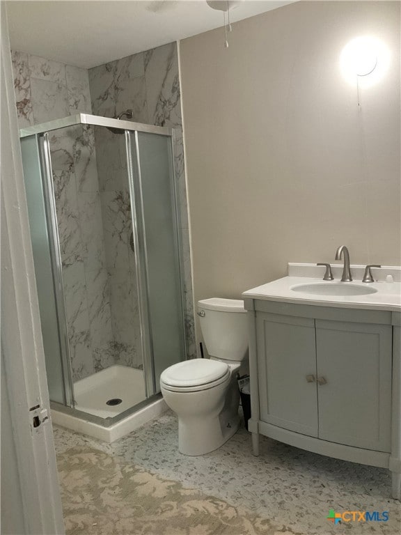 bathroom with tile patterned flooring, vanity, toilet, and a shower with door