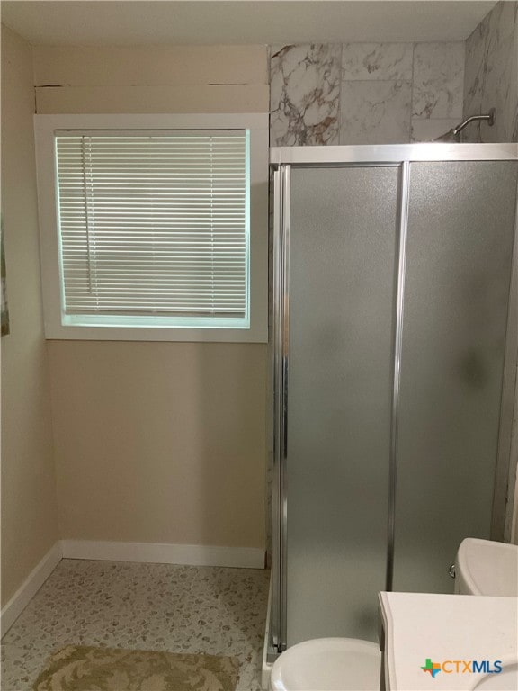 bathroom featuring a shower with door, vanity, and toilet