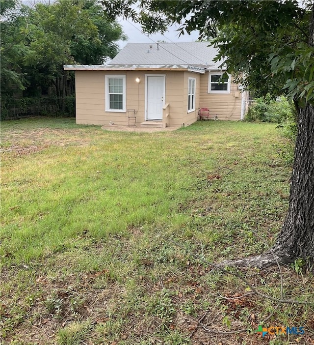 back of house featuring a lawn