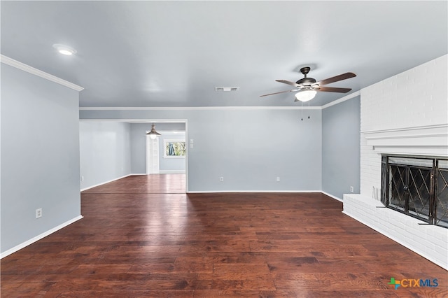 unfurnished living room featuring ceiling fan, crown molding, dark hardwood / wood-style floors, and a brick fireplace