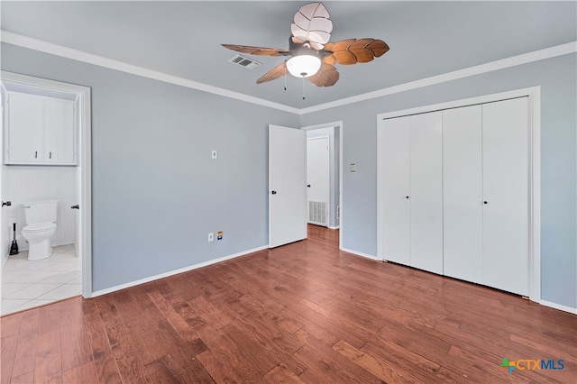 unfurnished bedroom with light hardwood / wood-style floors, ensuite bath, ornamental molding, ceiling fan, and a closet