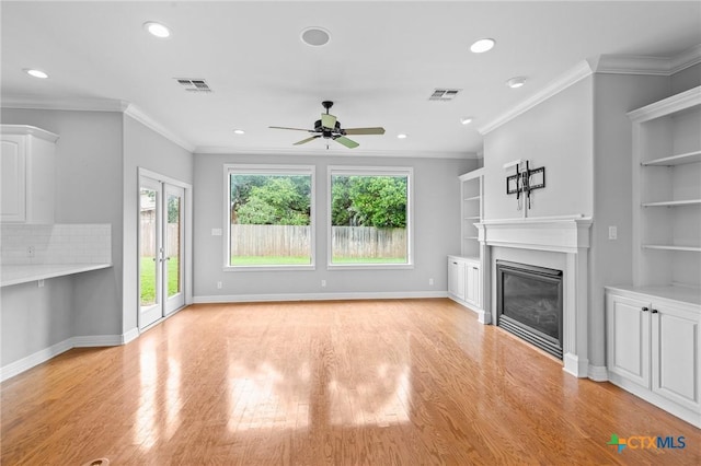 26 Cotswold Ln, Victoria, TX 77904 - unfurnished living room with ceiling fan, recessed lighting, a glass covered fireplace, light wood finished floors, and built in shelves