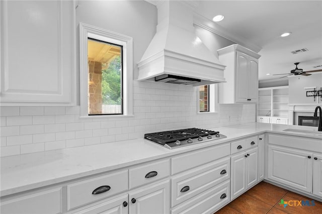 26 Cotswold Ln, Victoria, TX 77904 - kitchen featuring premium range hood, stainless steel gas cooktop, a ceiling fan, white cabinets, and dark tile patterned flooring