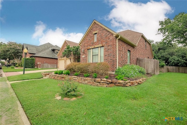 26 Cotswold Ln, Victoria, TX 77904 - view of front facade with an attached garage, brick siding, and driveway