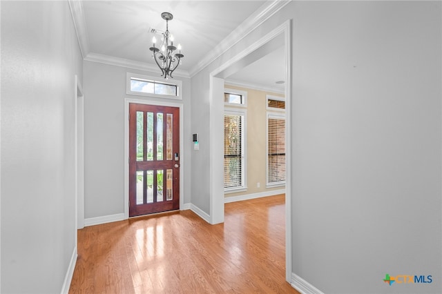 entrance foyer with crown molding, light hardwood / wood-style flooring, and an inviting chandelier