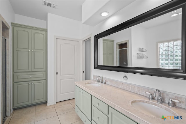 bathroom with tile patterned floors, vanity, an enclosed shower, and tasteful backsplash