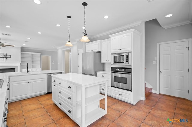 26 Cotswold Ln, Victoria, TX 77904 - kitchen with appliances with stainless steel finishes, crown molding, recessed lighting, light tile patterned flooring, and a center island