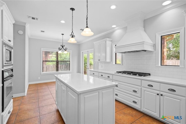 26 Cotswold Ln, Victoria, TX 77904 - kitchen featuring appliances with stainless steel finishes, ornamental molding, premium range hood, decorative backsplash, and light countertops