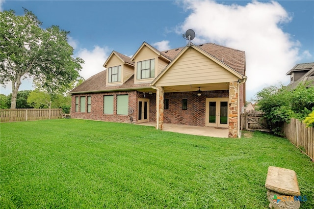 rear view of property featuring a lawn, a patio area, and french doors