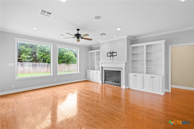 unfurnished living room featuring ceiling fan, light wood-type flooring, and ornamental molding