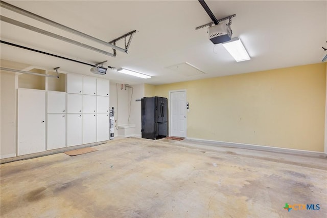 26 Cotswold Ln, Victoria, TX 77904 - garage with freestanding refrigerator and a garage door opener