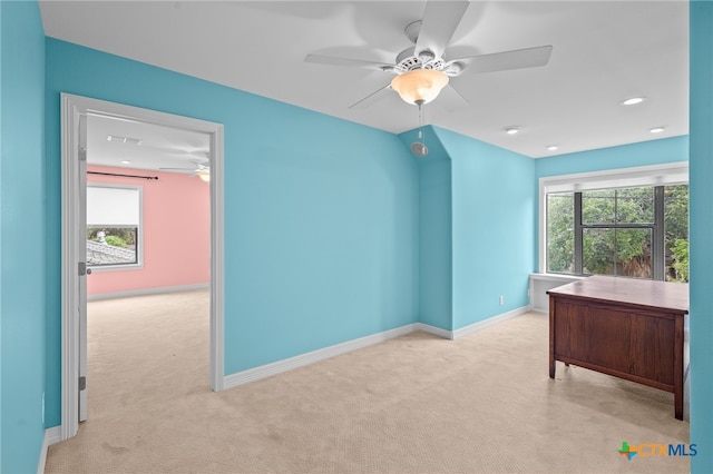 unfurnished office with ceiling fan and light colored carpet