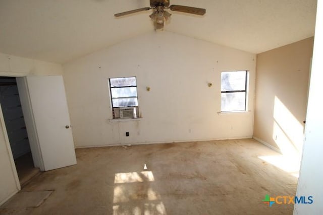 unfurnished room with cooling unit, a healthy amount of sunlight, and vaulted ceiling