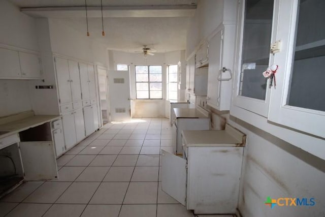 kitchen featuring ceiling fan, light countertops, light tile patterned flooring, and white cabinets