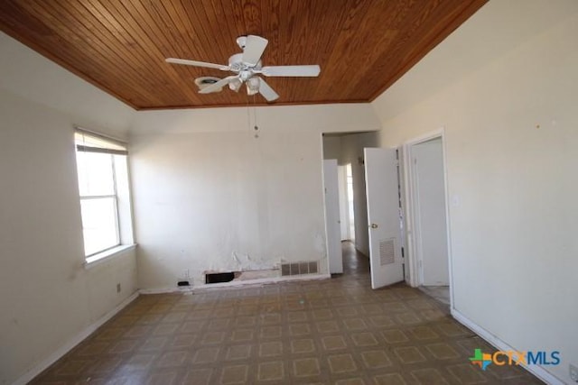 empty room with wooden ceiling, ceiling fan, visible vents, and baseboards