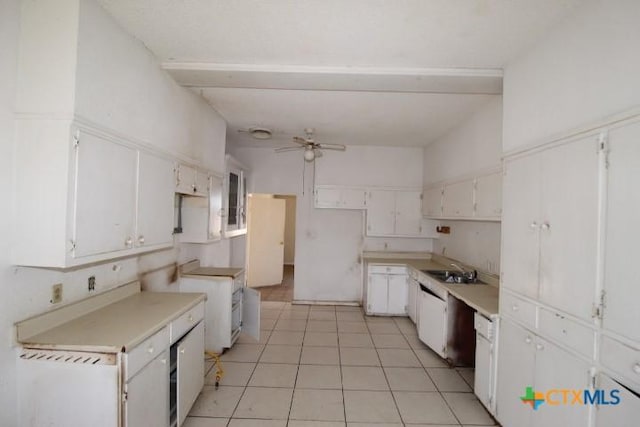 kitchen with ceiling fan, light tile patterned flooring, a sink, white cabinets, and beam ceiling