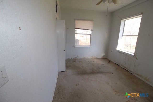 empty room with a ceiling fan and a healthy amount of sunlight