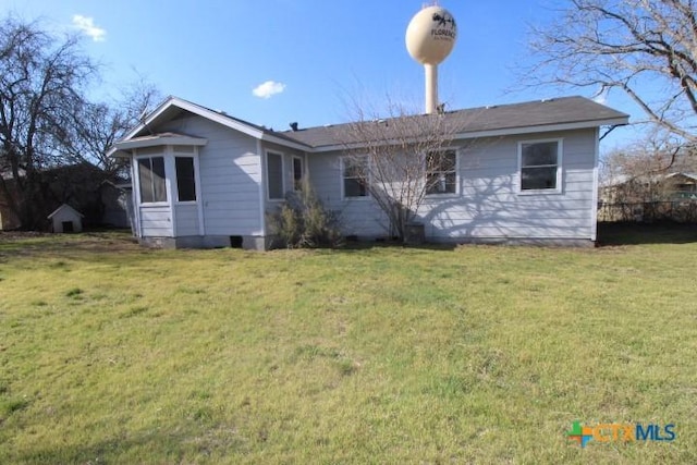 rear view of property with a lawn