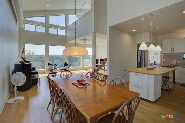1550 Moon View Dr, New Braunfels, TX 78132 - dining space featuring recessed lighting, visible vents, light wood-style flooring, and a towering ceiling