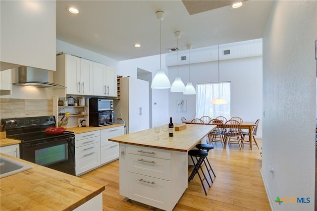 1550 Moon View Dr, New Braunfels, TX 78132 - kitchen with white cabinets, butcher block counters, a breakfast bar, and black electric range oven
