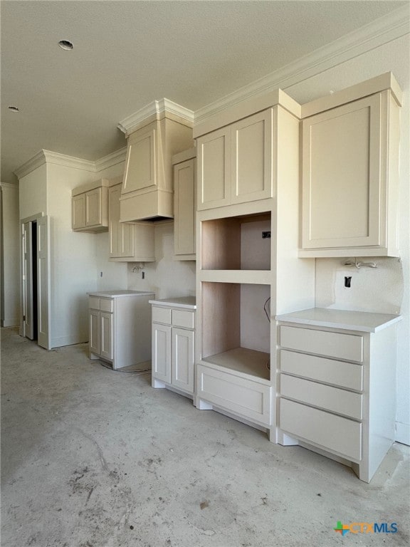 kitchen with concrete floors and crown molding