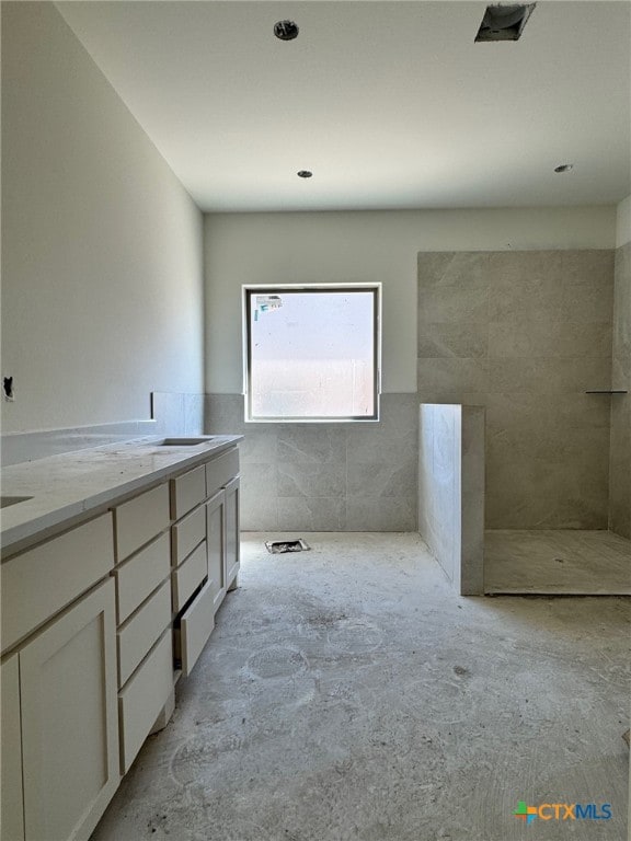 bathroom with concrete floors and double vanity