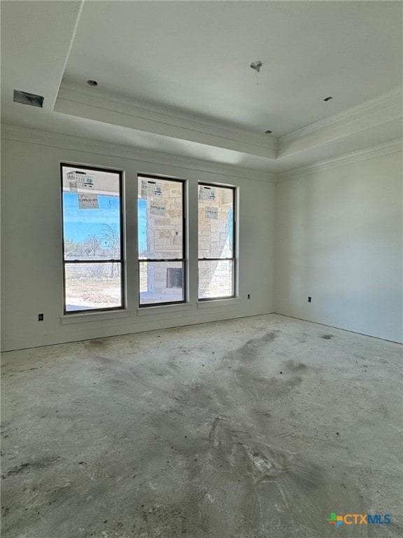 unfurnished room featuring concrete flooring, a raised ceiling, and crown molding