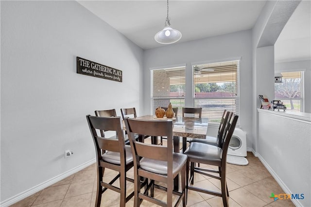 dining space featuring light tile patterned floors and baseboards