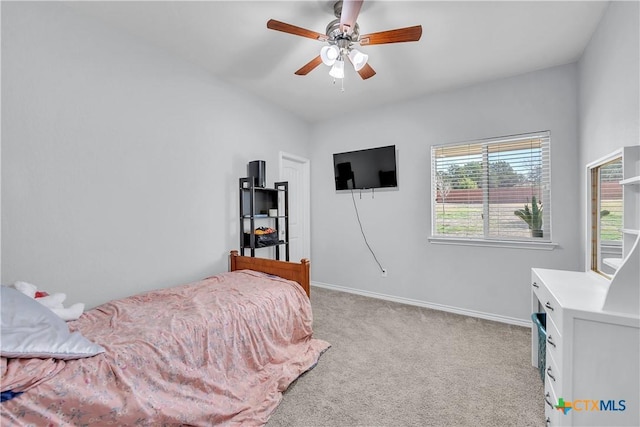 bedroom featuring baseboards, light colored carpet, and a ceiling fan